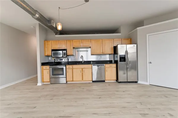 a kitchen with stainless steel appliances kitchen island granite countertop a refrigerator and a stove top oven
