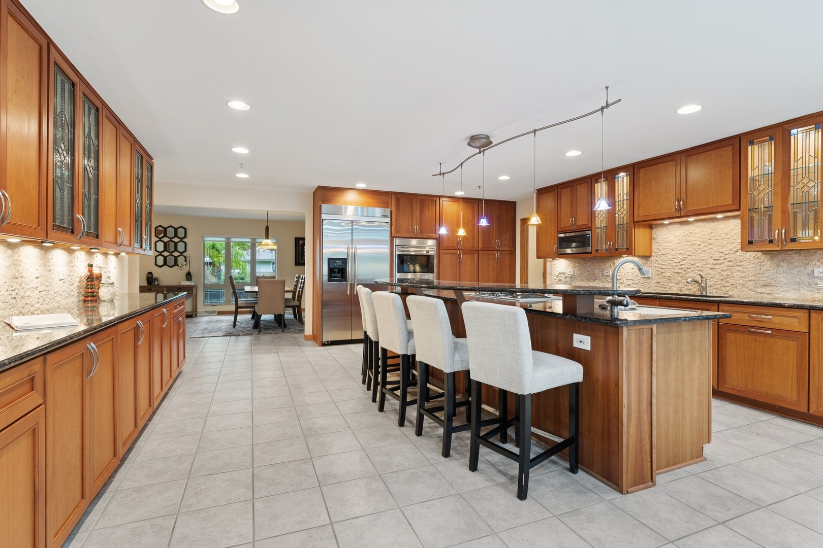 2037 Clover Road Northbrook, IL 60062 - Photo 4 of 29 a kitchen with stainless steel appliances kitchen island granite countertop a table chairs sink and cabinets