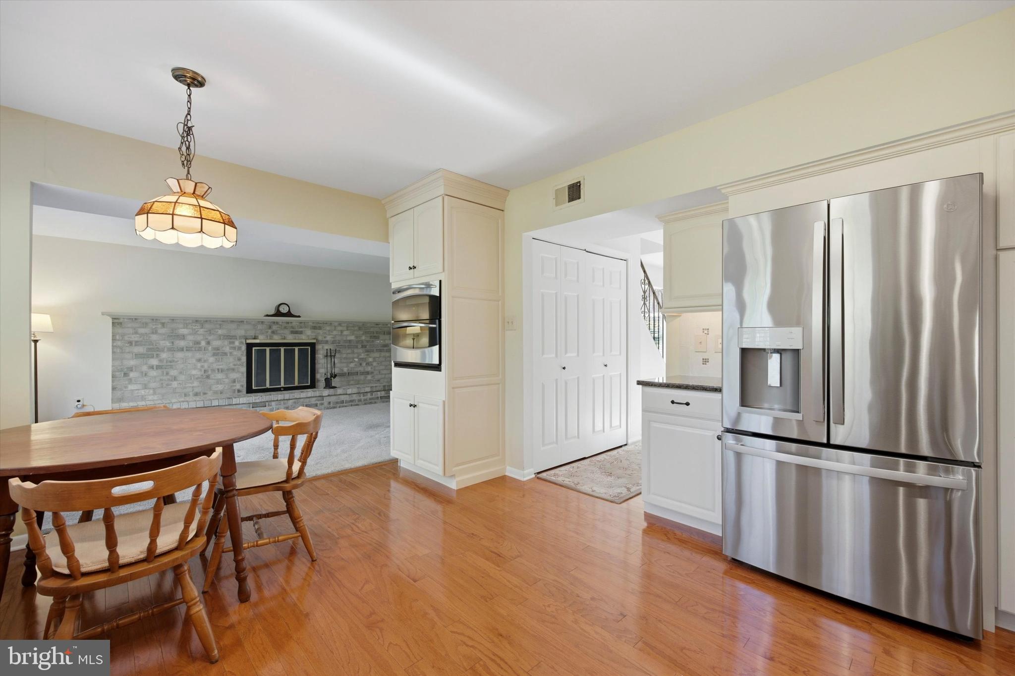 1965 Foster Road Hatfield, PA 19440 - Photo 4 of 38 a kitchen with stainless steel appliances granite countertop a refrigerator a stove a kitchen island a dining table and chairs with wooden floor