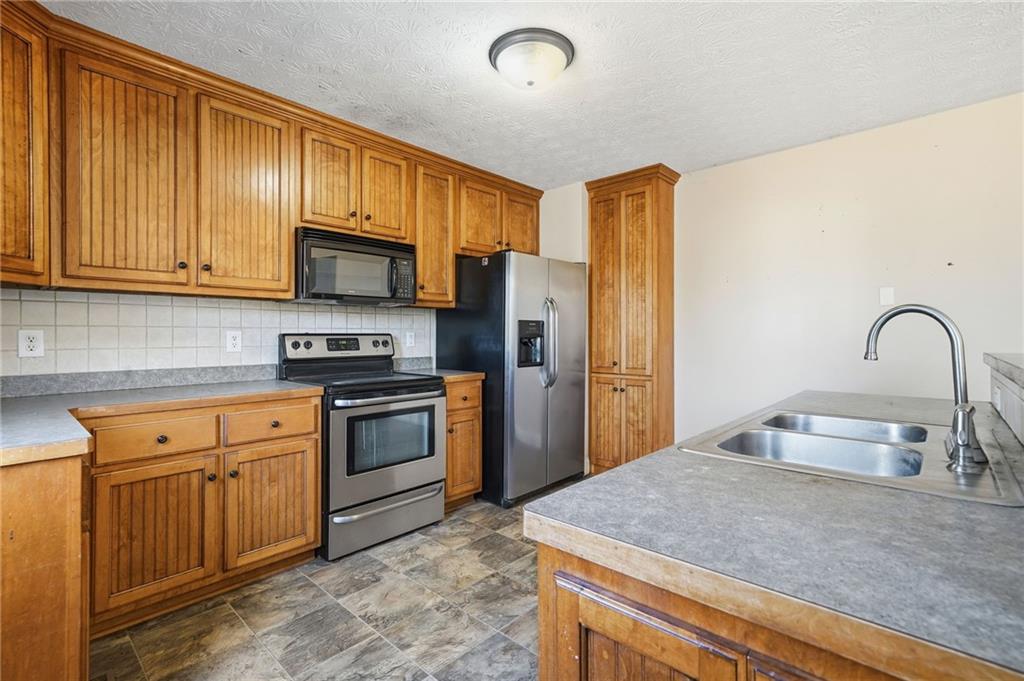 27 Larsen Ridge Adairsville, GA 30103 - Photo 16 of 47 a kitchen with stainless steel appliances granite countertop a stove a sink dishwasher a refrigerator and a microwave oven