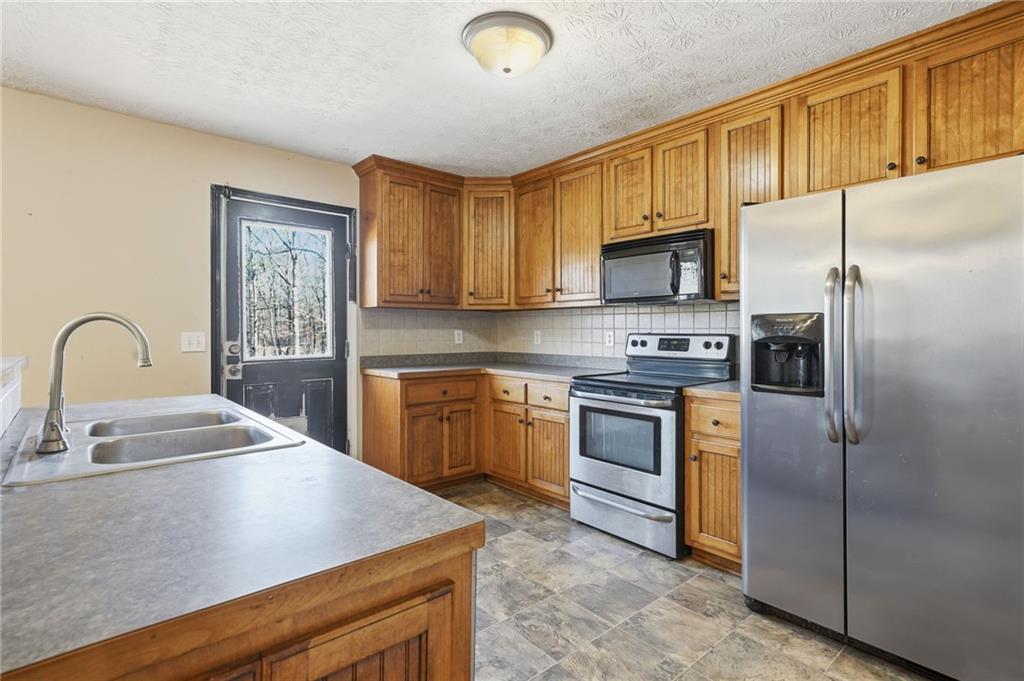 27 Larsen Ridge Adairsville, GA 30103 - Photo 2 of 47 a kitchen with stainless steel appliances granite countertop a stove a sink dishwasher a refrigerator and a microwave