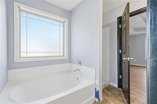 a white bath tub sitting next to a shower