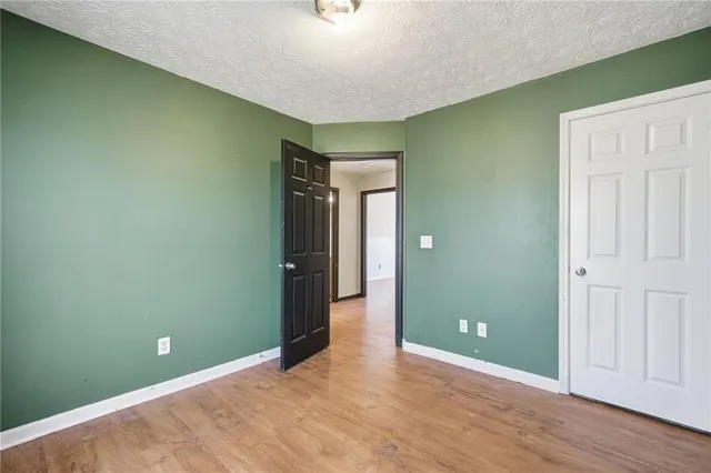 an empty room with wooden floor and closet