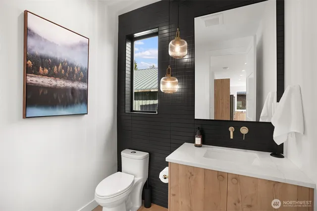 a bathroom with a granite countertop sink mirror vanity and toilet