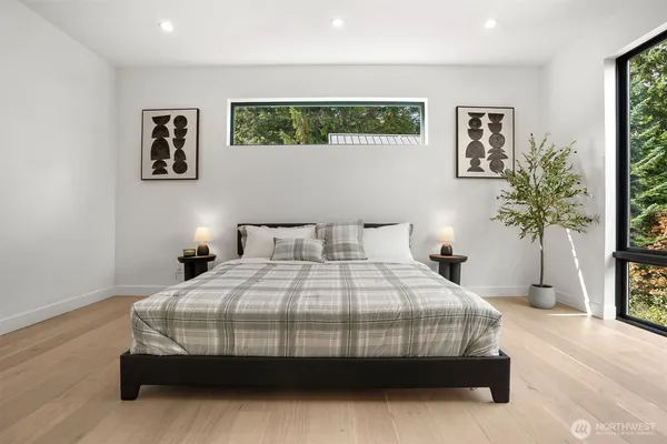 a bedroom with a large bed and a potted plant