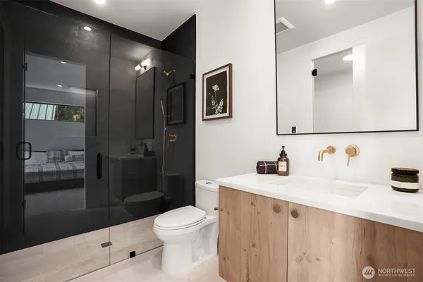 a bathroom with a sink a toilet and shower