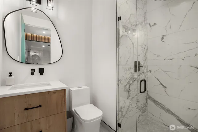 a bathroom with a toilet sink vanity and mirror