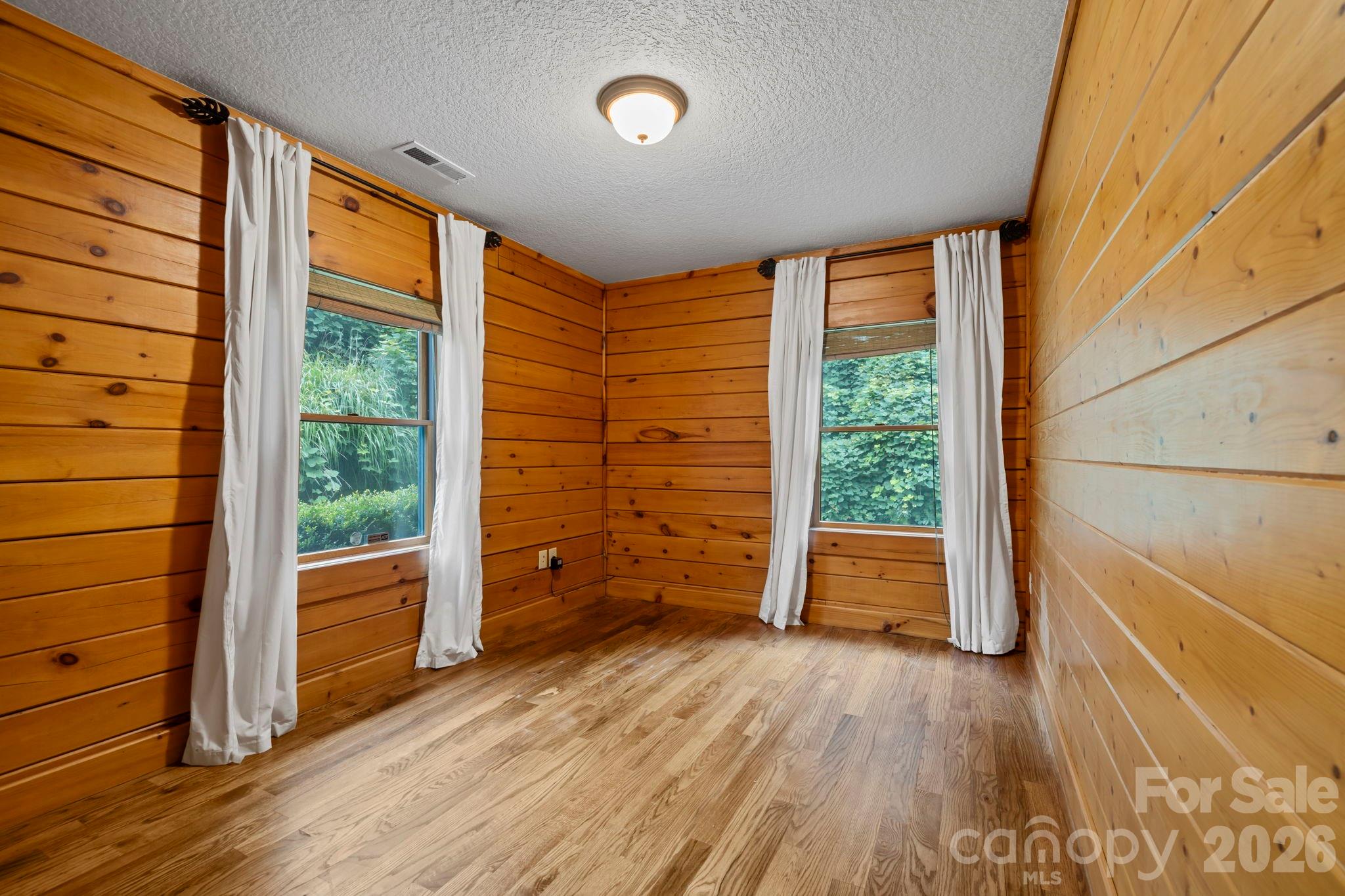 266 Rhododendron Drive Saluda, NC 28773 - Photo 17 of 35 a view of an empty room with wooden floor and a window