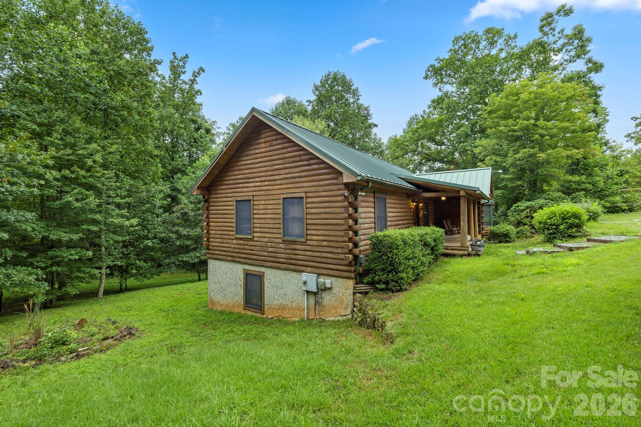 266 Rhododendron Drive Saluda, NC 28773 - Photo 5 of 35 a view of a house with a yard and a garden