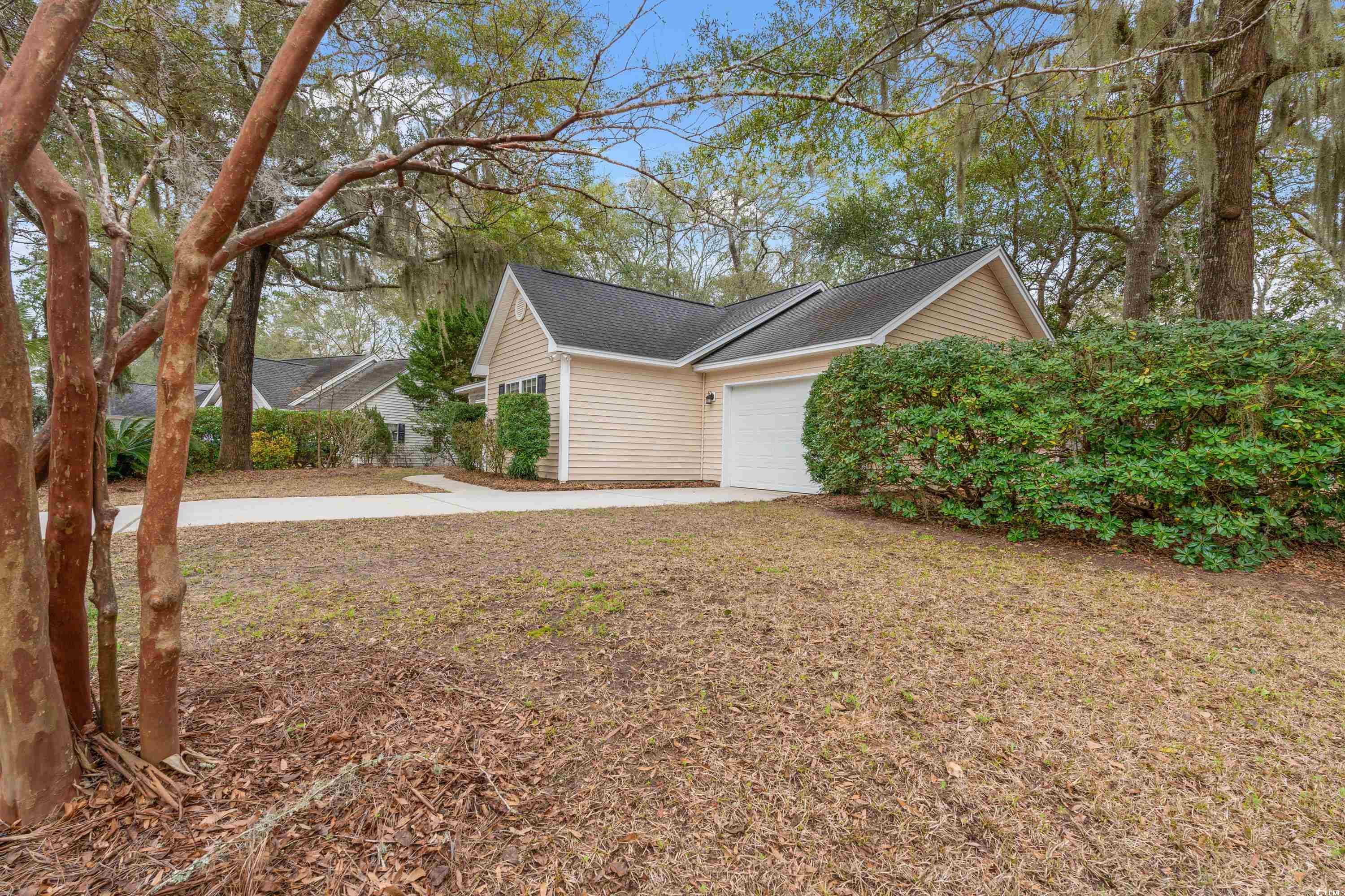 177 Reef Run Road Pawleys Island, SC 29585 - Photo 29 of 40 View of side of home with concrete driveway and an