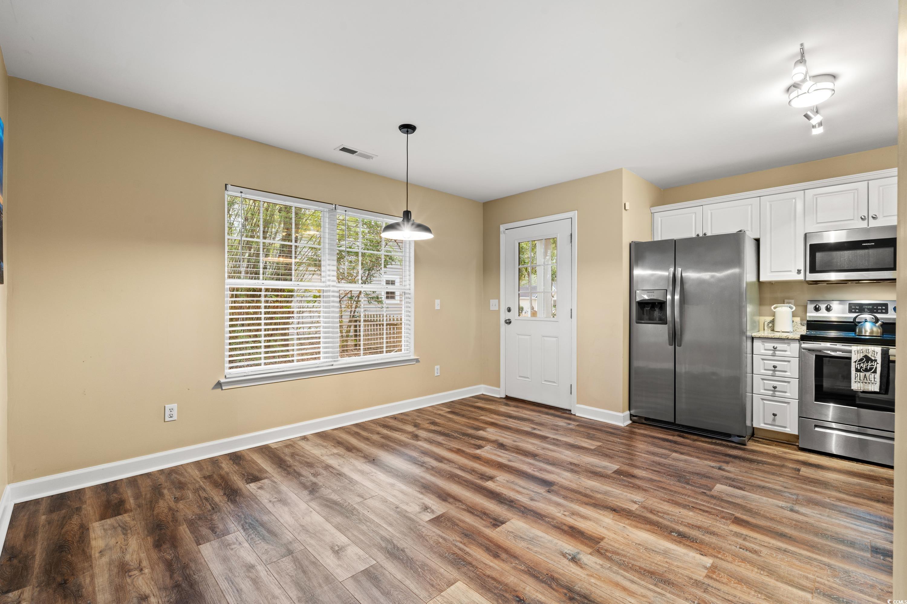 Kitchen featuring visible vents, white cabinetry,