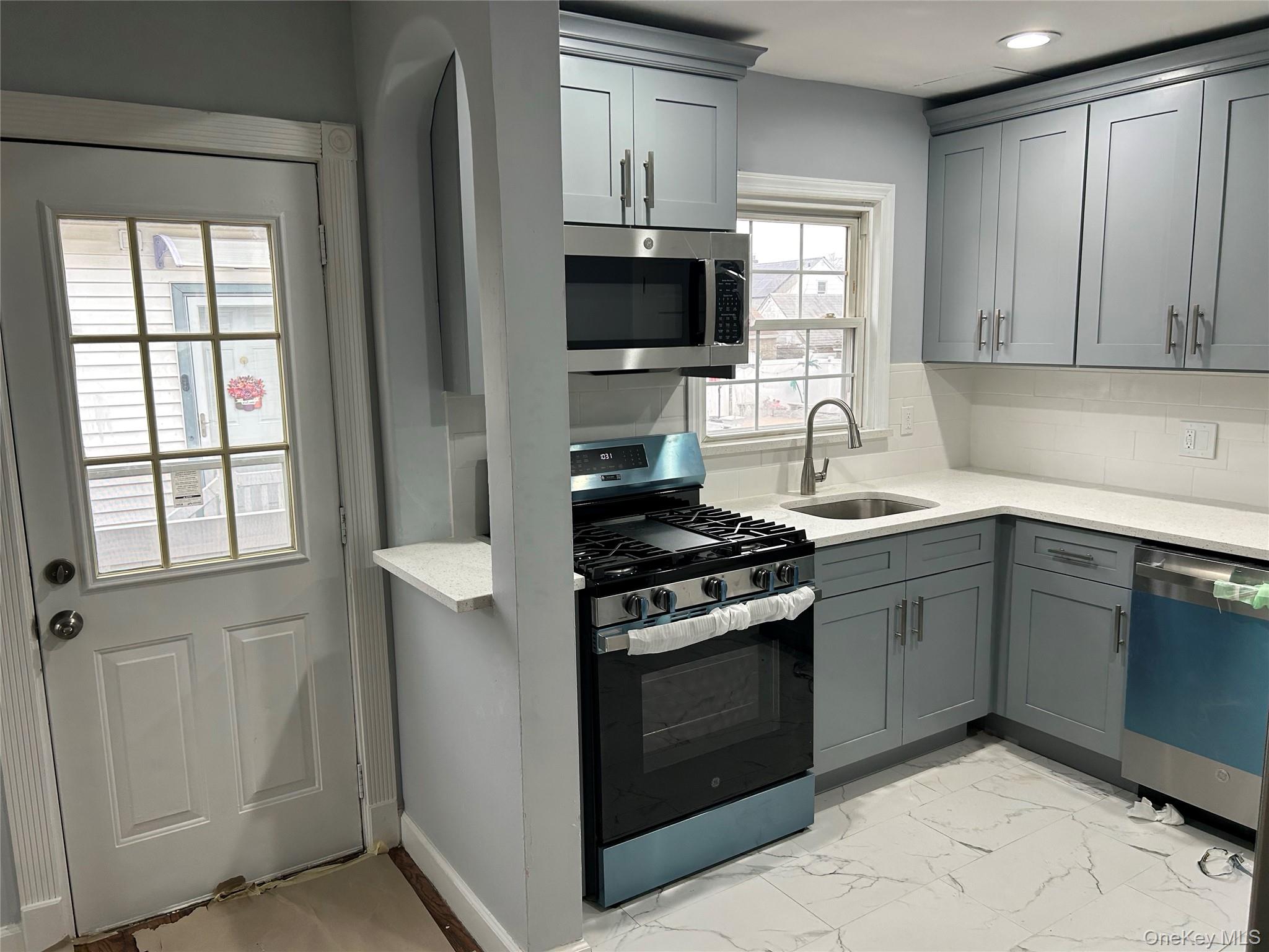 42 Princeton Street Valley Stream, NY 11580 - Photo 10 of 13 Kitchen with appliances with stainless steel finishes, light marble finish floors, gray cabinets, and light stone counters