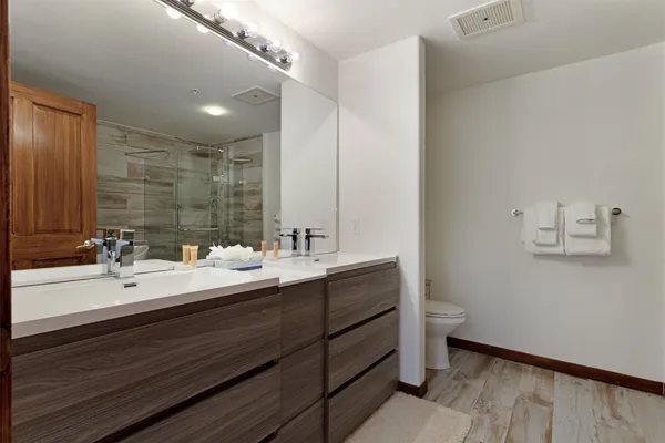 a bathroom with a double vanity sink mirror and toilet