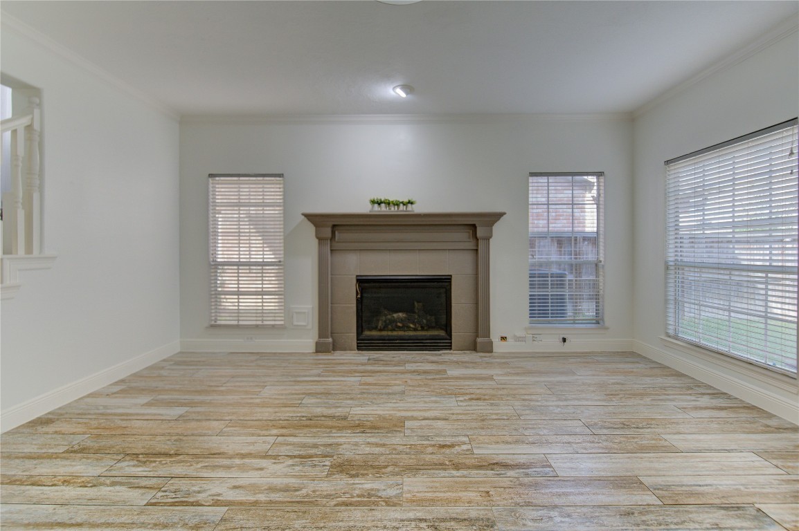 1115 Enclave Square East Houston, TX 77077 - Photo 16 of 42 A cozy fireplace serves as the focal point, perfect for relaxing evenings, while large windows enhance the space with natural light. The layout offers plenty of room for comfortable seating and entertaining, seamlessly connecting to the dining and kitchen areas for easy flow and functionality.