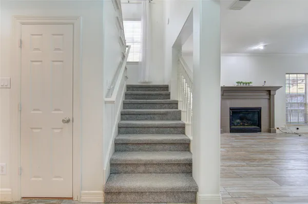 a view of an entryway with wooden floor and a fireplace