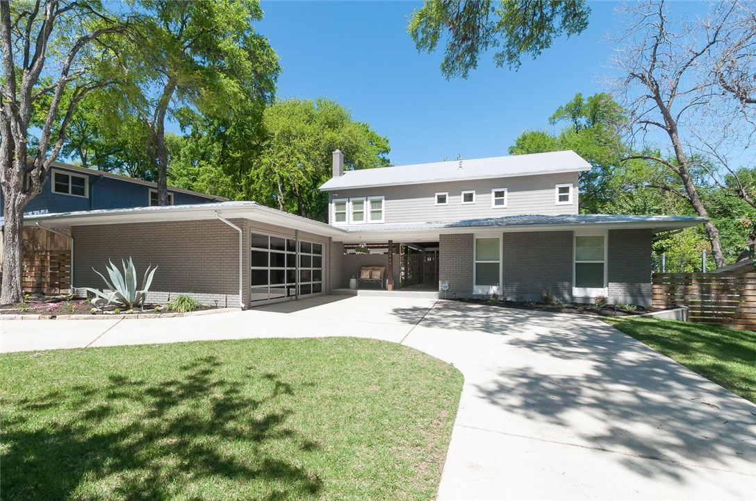 a front view of a house with a yard and potted plants