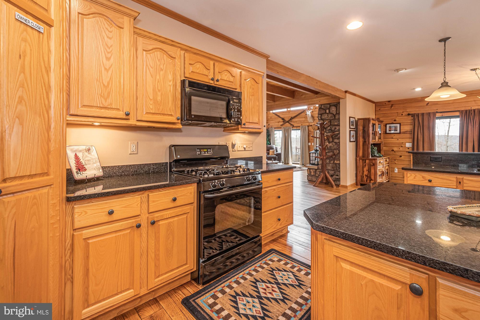 642 Deep Creek Highlands Road McHenry, MD 21541 - Photo 16 of 59 a kitchen with stainless steel appliances granite countertop a stove a sink and a microwave