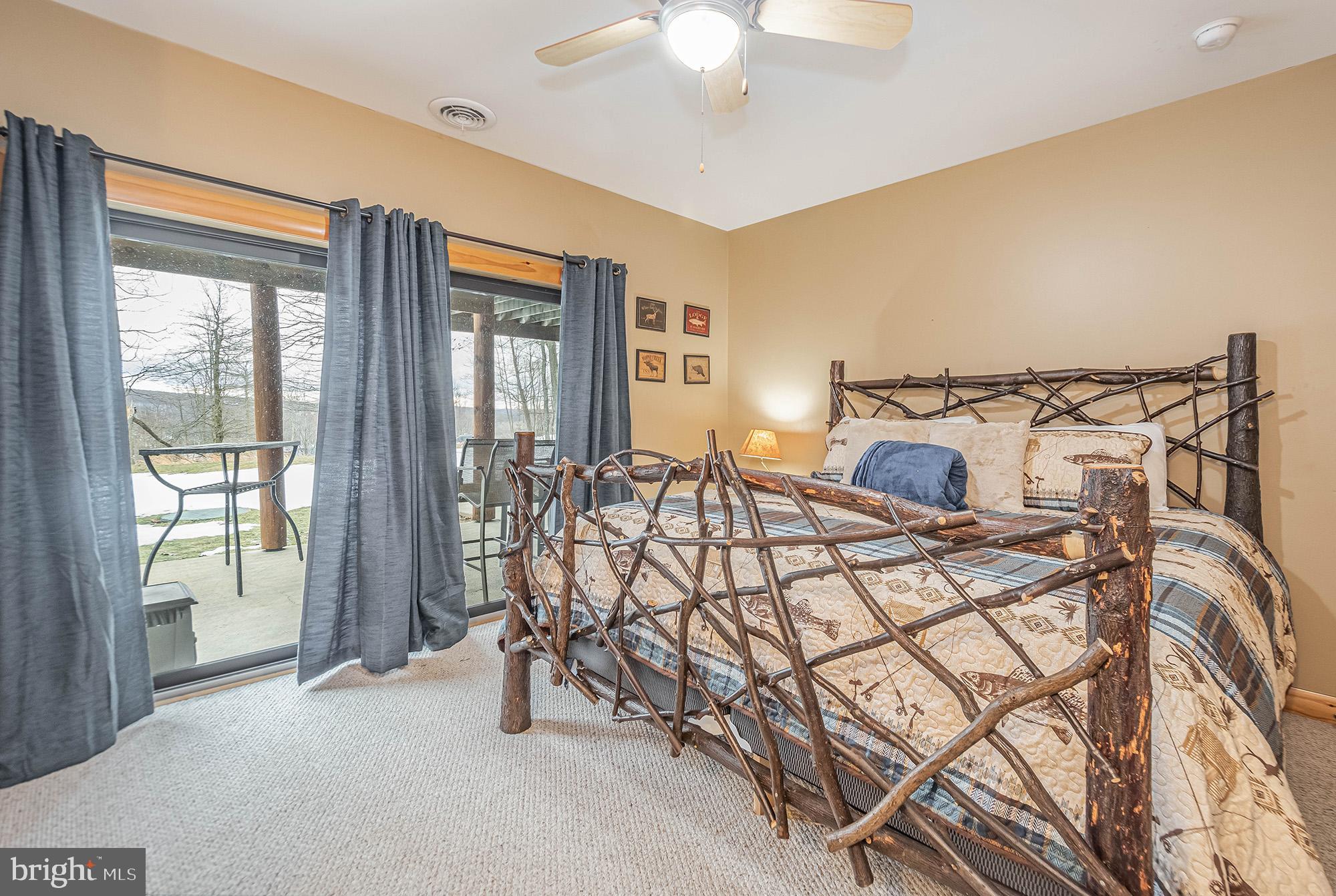 642 Deep Creek Highlands Road McHenry, MD 21541 - Photo 27 of 59 a bedroom with a bed and a chandelier