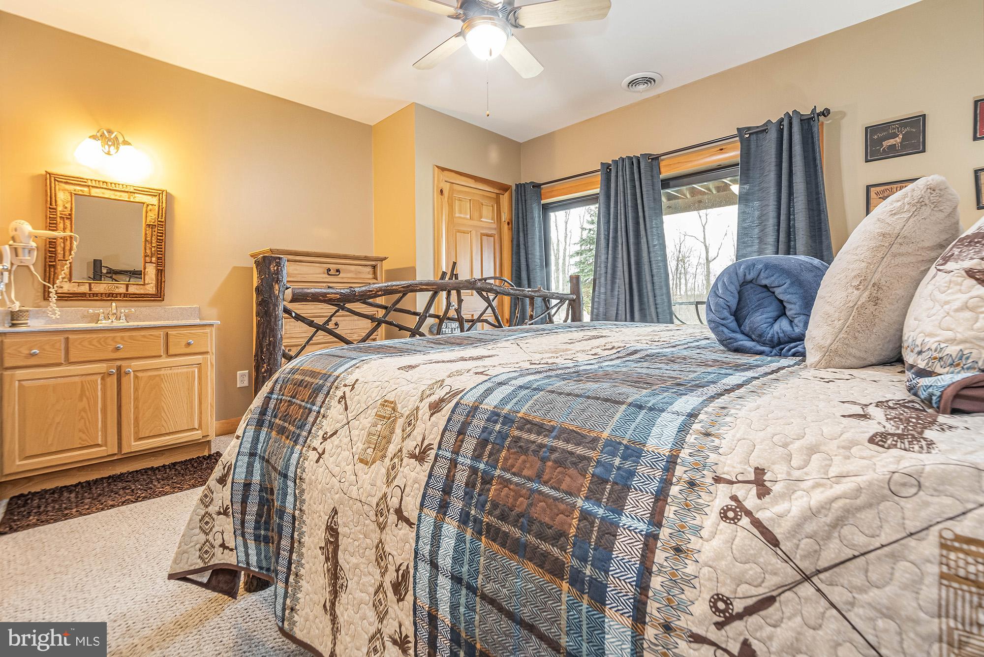 642 Deep Creek Highlands Road McHenry, MD 21541 - Photo 28 of 59 a bedroom with a large bed and a chandelier