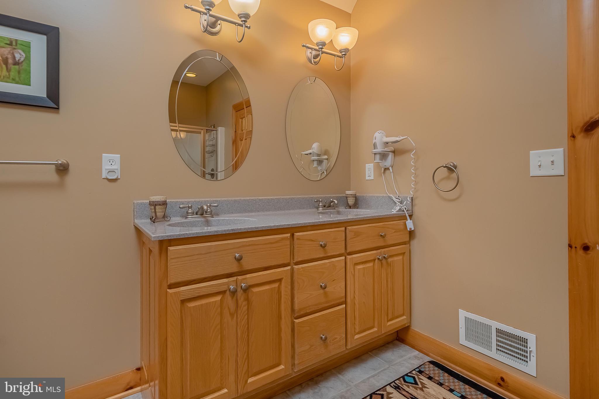 642 Deep Creek Highlands Road McHenry, MD 21541 - Photo 38 of 59 a bathroom with a granite countertop sink a mirror and a vanity