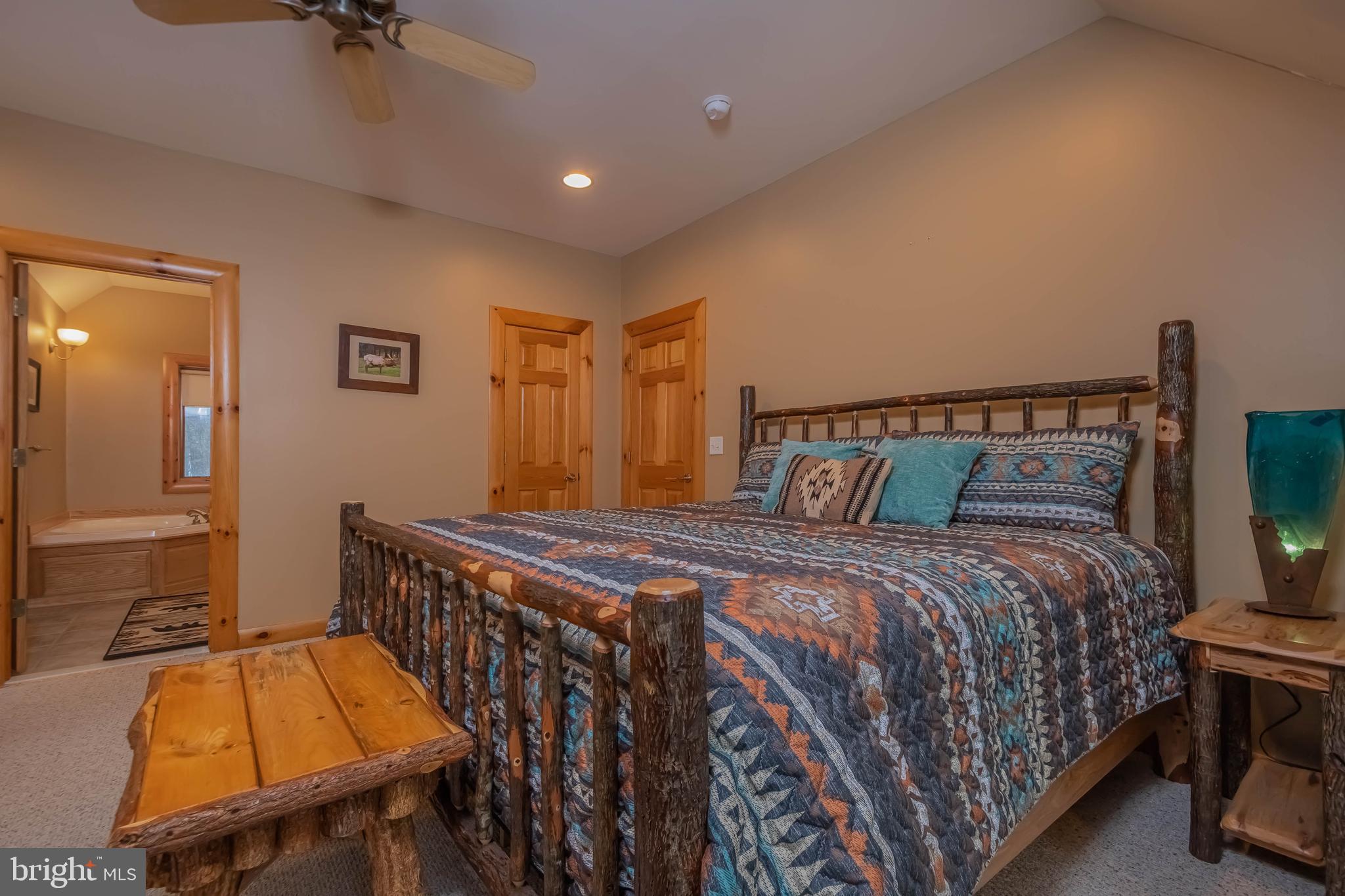 642 Deep Creek Highlands Road McHenry, MD 21541 - Photo 43 of 59 a bedroom with a bed and a chandelier