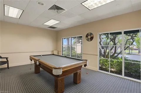 a room with pool table and wooden floor