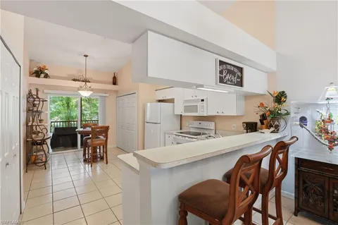 a kitchen with kitchen island a dining table and chairs