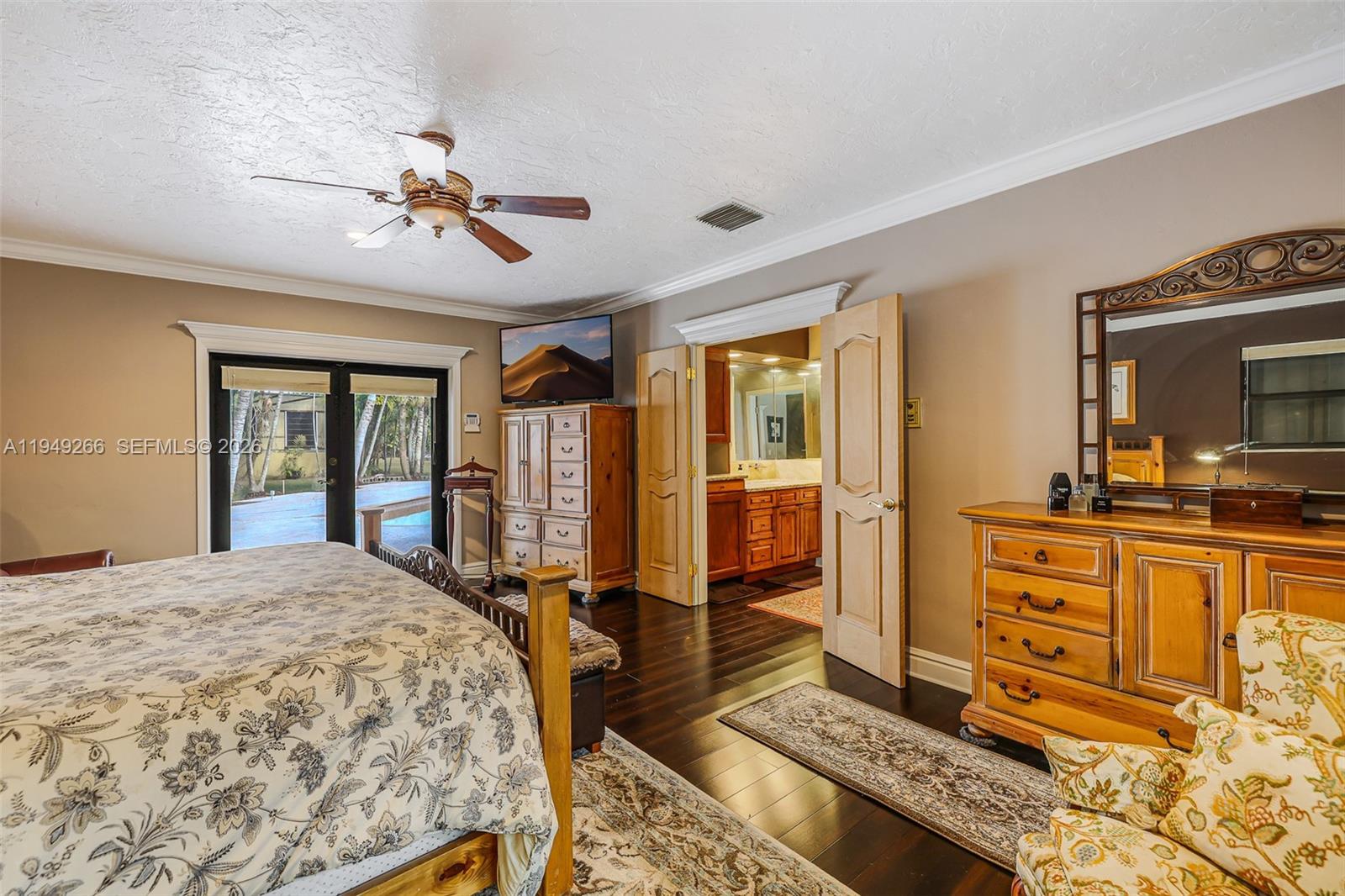 18975 Southwest 224th Street Miami, FL 33170 - Photo 43 of 97 a spacious bedroom with a large bed a flat tv screen and dresser