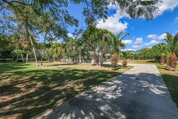 a view of a house with a patio and a yard