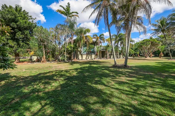a view of a house with a yard and potted plants