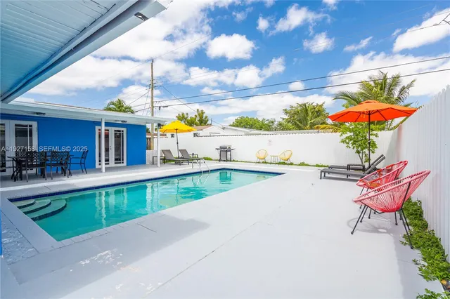 a view of a swimming pool with a patio and a yard