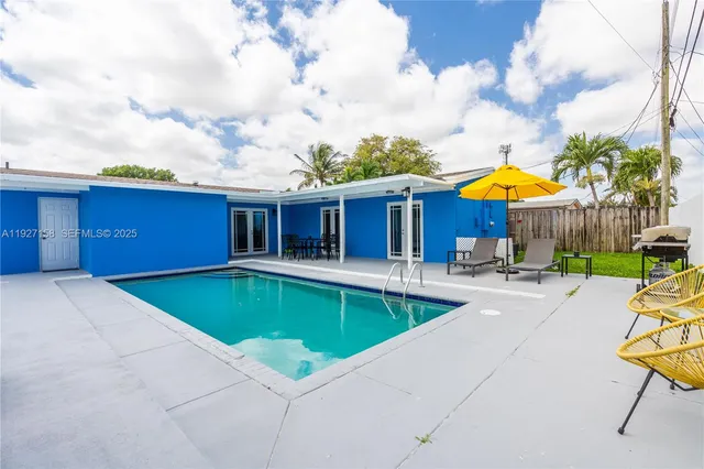 a view of house with swimming pool and furniture