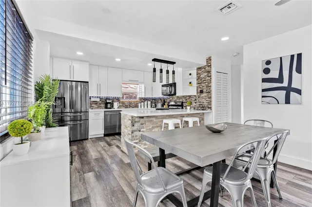 a kitchen with a table chairs refrigerator and microwave