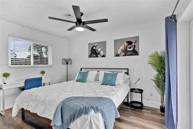 a bedroom with a large bed and a potted plant