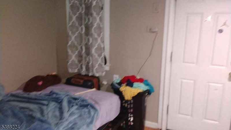 249 Summer Avenue Newark, NJ 07104 - Photo 5 of 16 a bedroom with a bed and a chandelier