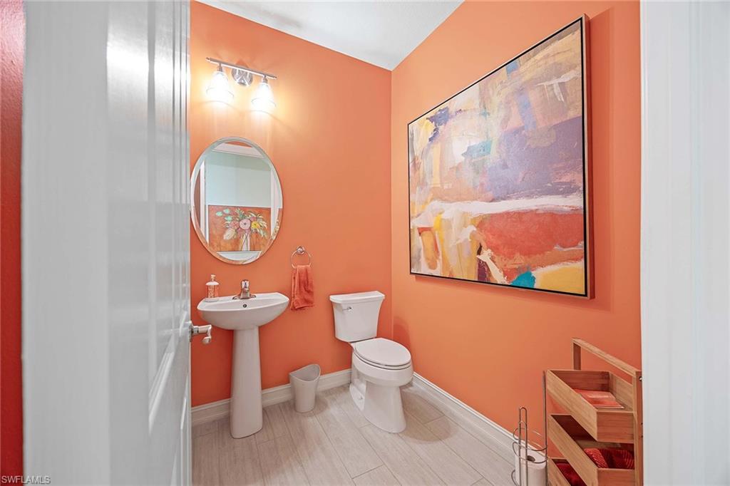 9076 Rialto Street, Unit 62 Naples, FL 34113 - Photo 18 of 50 a bathroom with a toilet sink and mirror