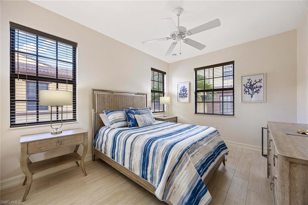 9076 Rialto Street, Unit 62 Naples, FL 34113 - Photo 27 of 50 a bedroom with a large bed and a chandelier
