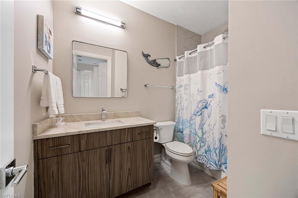 9076 Rialto Street, Unit 62 Naples, FL 34113 - Photo 28 of 50 a bathroom with a granite countertop sink toilet a mirror and shower