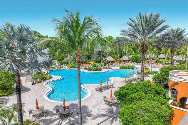 a view of a swimming pool with a table and chairs potted plants
