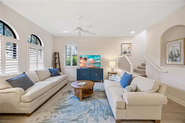 a living room with furniture a rug and a window