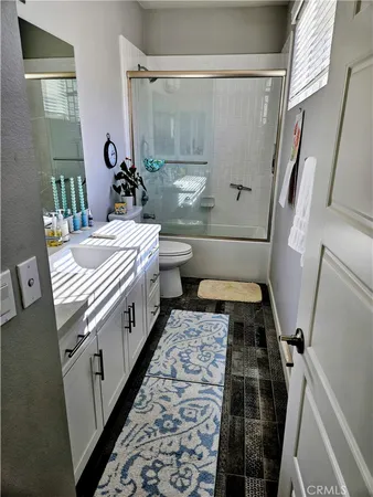 a bathroom with a double vanity sink toilet and shower