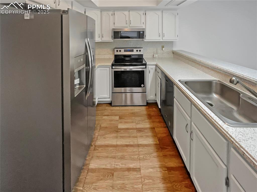 34 Rising Sun Terrace Colorado Springs, CO 80921 - Photo 6 of 20 a kitchen with granite countertop a refrigerator and a stove