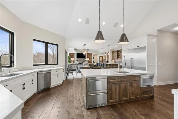 a kitchen with stainless steel appliances granite countertop a sink a stove and a wooden floors