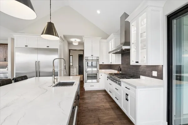 a kitchen with stainless steel appliances a sink stove and cabinets