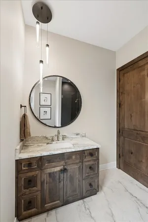 a bathroom with a granite countertop sink mirror vanity and toilet