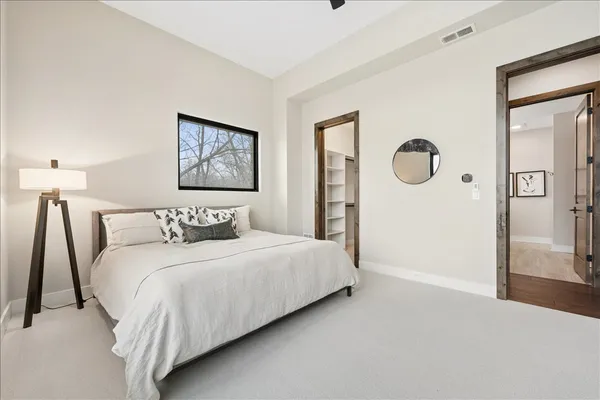 a large bed sitting in a bedroom next to a large window