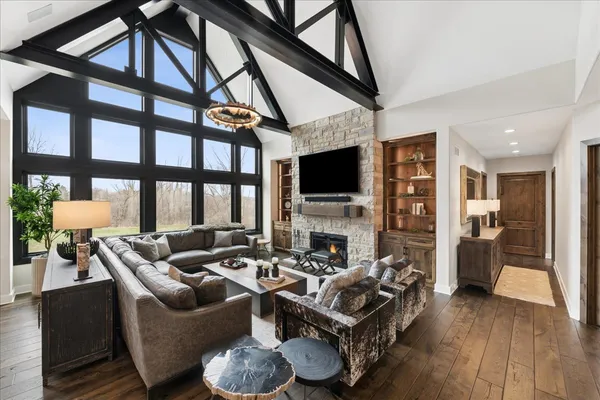 a living room with furniture a flat screen tv and a floor to ceiling window