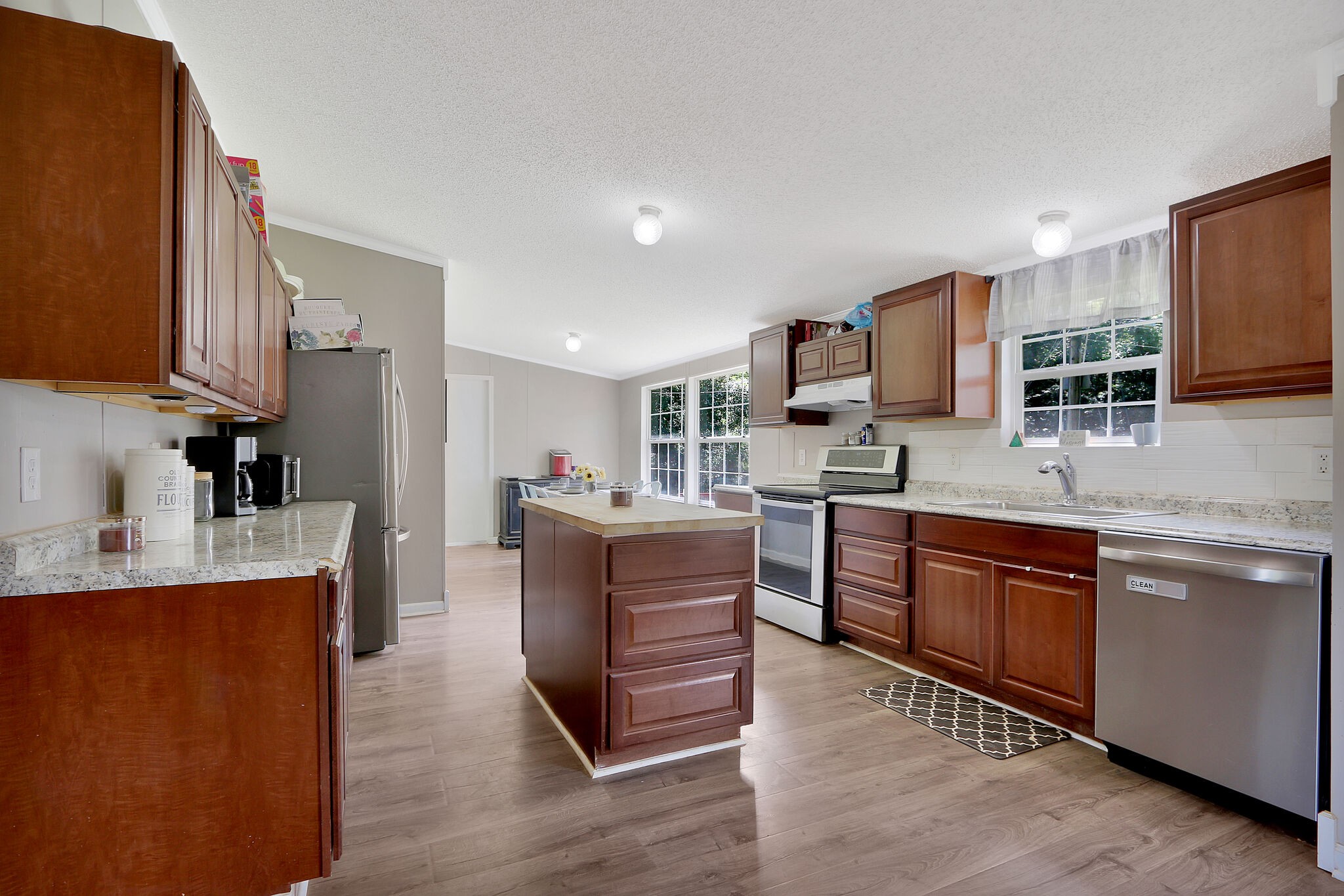 2218 Lee Road Spring Hill, TN 37174 - Photo 6 of 19 a kitchen with kitchen island granite countertop a stove top oven a sink dishwasher and a refrigerator with wooden floor