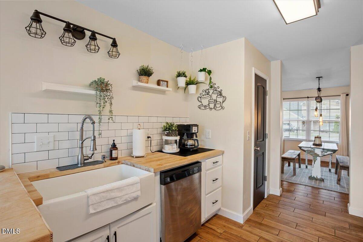 205 Battery Way Bunnlevel, NC 28323 - Photo 19 of 37 a kitchen with a sink a stove and white cabinets with wooden floor