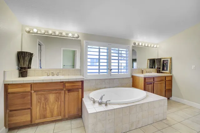 a bathroom with a double vanity sink mirror and shower
